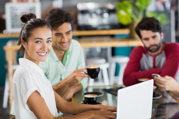 Portrait, femme, utilisation, ordinateur portable, café