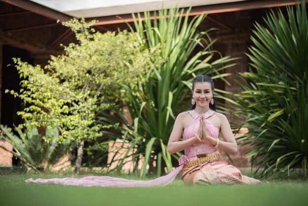 Photo portrait d'une femme en vêtements traditionnels assise sur l'herbe