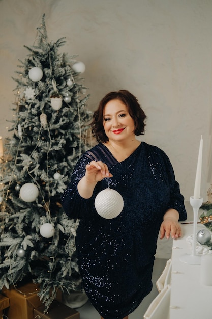 Portrait d'une femme vêtue d'une robe bleue brillante dans un intérieur du Nouvel An Concept Joyeux Noël et Bonne Année