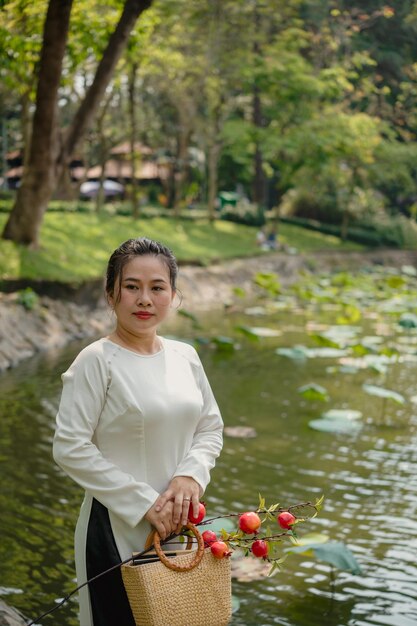 Portrait d'une femme vietnamienne en ao dai blanc en plein air