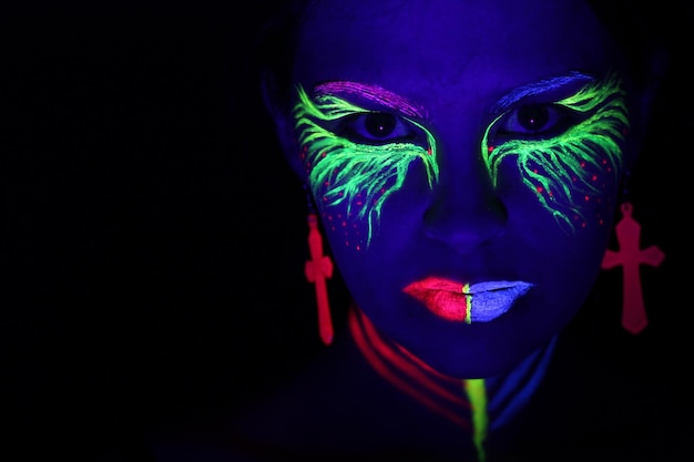 Portrait d'une femme avec le visage peint sur un fond noir