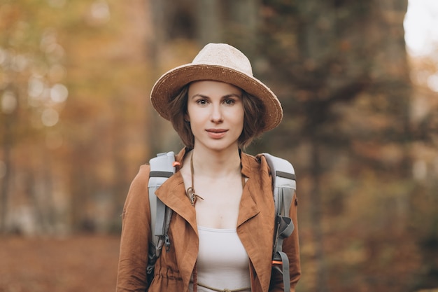 Portrait femme voyageur avec sac à dos regardant la forêt incroyable, concept de voyage