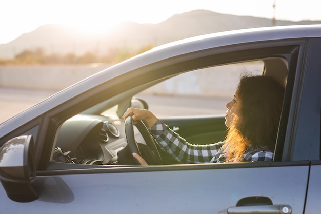 Portrait d'une femme vu à travers une voiture
