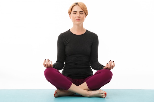 Portrait d'une femme de yoga méditant en position du lotus
