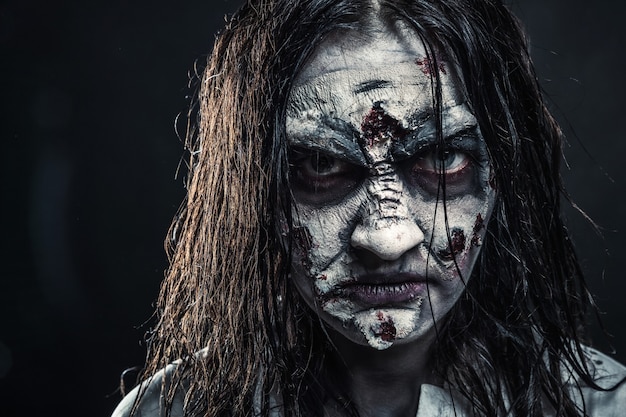 Portrait de la femme zombie d'horreur au visage ensanglanté. Halloween. Angoissant.