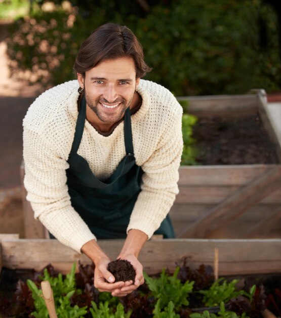 Portrait d'un fermier et d'un homme avec du sol pour l'agriculture, du sourire et de l'écologie pour la durabilité de la nature, du visage d'un jardinier et d'une personne heureuse avec de l'engrais, de la terre et de la saleté pour la croissance des plantes dans l'environnement.