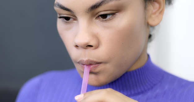 Photo portrait d'une fille afro-américaine buvant du jus d'une paille