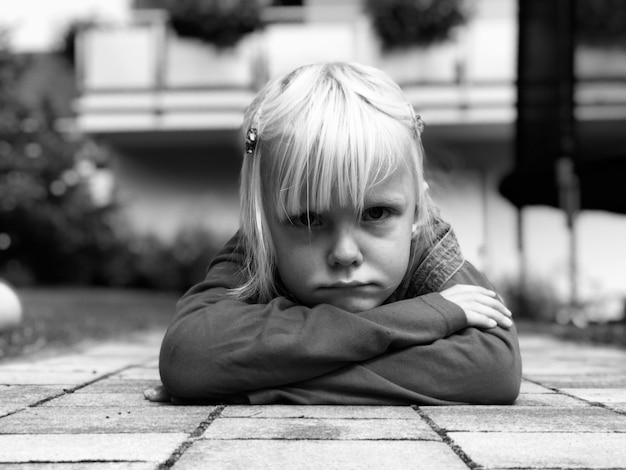 Photo portrait d'une fille allongée sur un trottoir