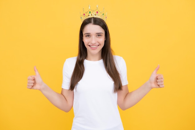 Portrait d'une fille ambitieuse avec couronne sentiment princesse confiance Studio tourné isolé sur jaune