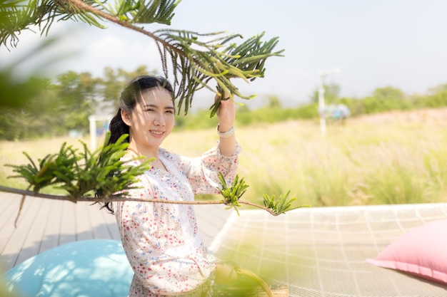 Portrait d'une fille asiatique recherchant calme et tranquillité dans un jardin fleuri.