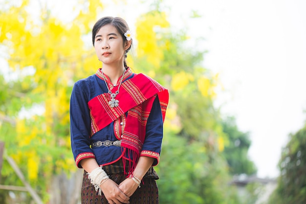 Portrait de fille asiatique avec la robe traditionnelle locale thaïlandaise célèbre dans la campagne de la Thaïlande