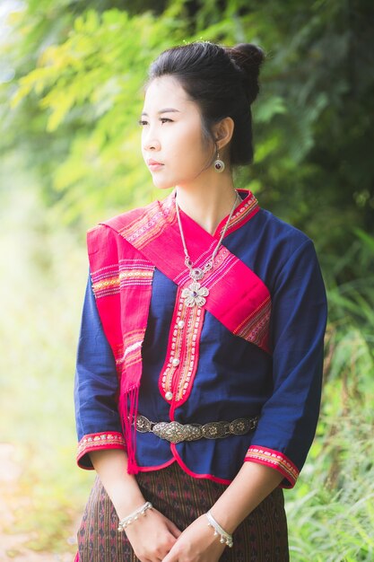 Portrait de fille asiatique avec la robe traditionnelle locale thaïlandaise célèbre dans la campagne de la Thaïlande