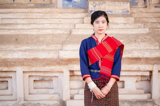 Portrait de fille asiatique avec la robe traditionnelle locale thaïlandaise célèbre dans la campagne de la Thaïlande