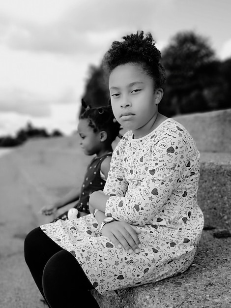Portrait d'une fille assise avec sa sœur sur les marches