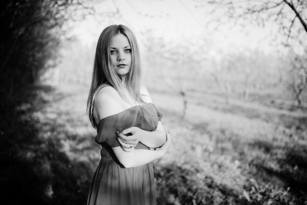 Portrait de fille aux cheveux clairs sur fond de robe rouge jardin de printemps