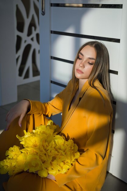 Photo portrait d'une fille aux cheveux longs et un bouquet de tulipes jaunes 4599