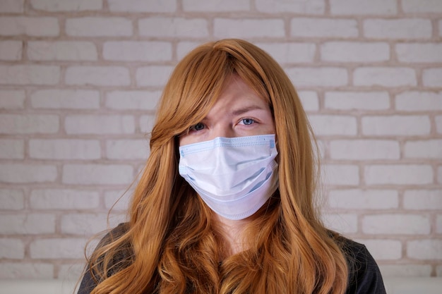 Portrait de fille aux cheveux roux dans un masque médical. covid-19