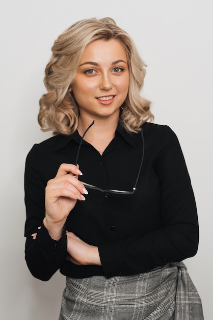 Portrait d'une fille blonde sur un fond gris