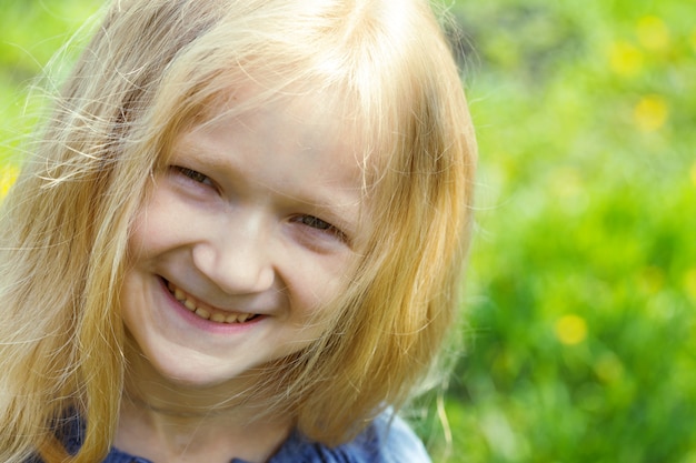 Portrait de fille blonde souriante à l'extérieur