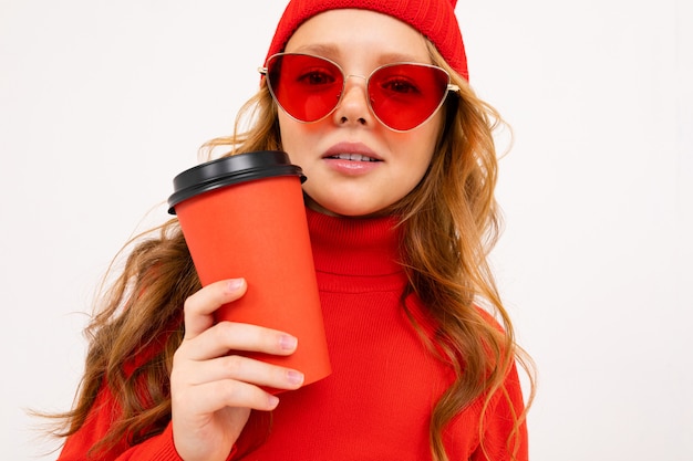 Portrait d'une fille avec un chapeau rouge et des lunettes de soleil avec un verre