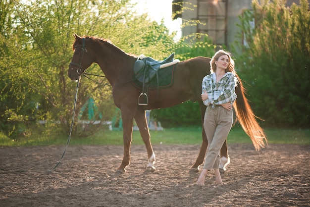 Portrait de fille chemise à carreaux avec cheval noir dans la ferme équestre.