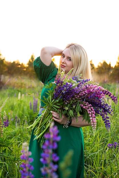 Portrait d'une fille dans un champ fleuri au soleil au coucher du soleil