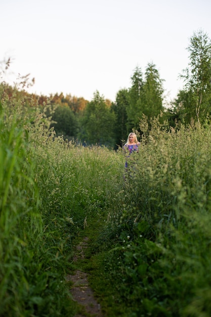 Portrait d'une fille dans un champ fleuri au soleil au coucher du soleil