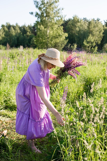 Portrait d'une fille dans un champ fleuri au soleil au coucher du soleil