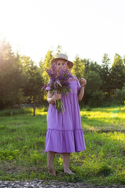 Portrait d'une fille dans un champ fleuri au soleil au coucher du soleil