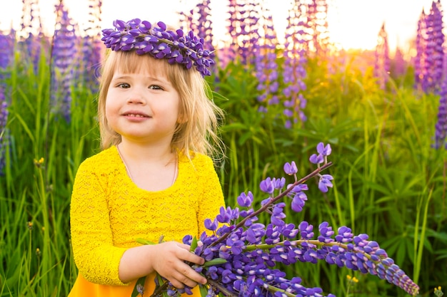 Portrait d'une fille dans un champ fleuri au soleil au coucher du soleil