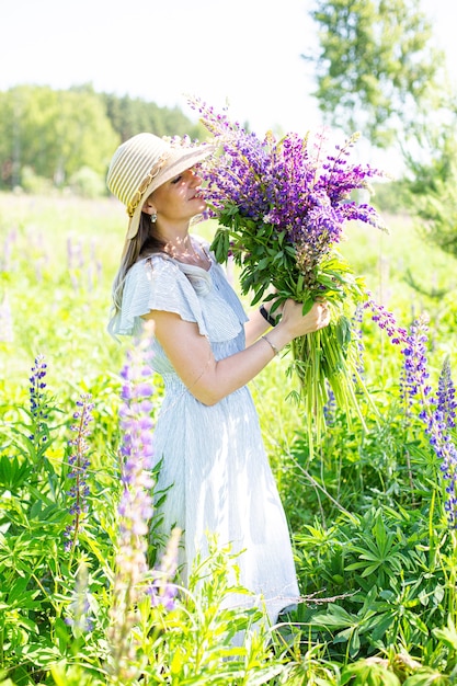 Portrait d'une fille dans un champ fleuri au soleil au coucher du soleil