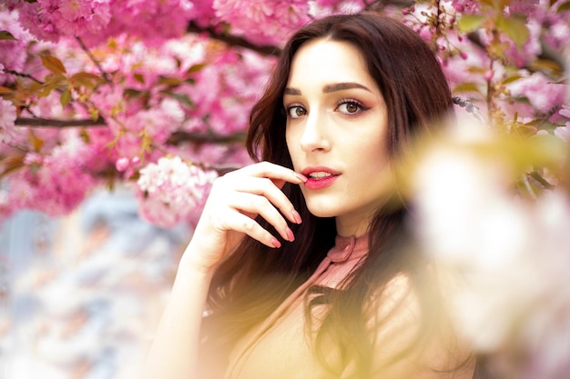 Portrait d'une fille dans le contexte d'un jardin avec sakura