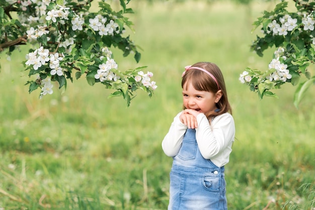 Portrait d'une fille dans un jardin de printemps près de pommiers en fleurs