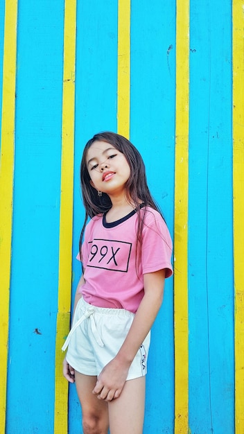 Photo portrait d'une fille debout contre le mur