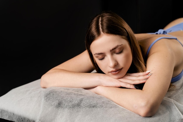 Portrait d'une fille détendue allongée sur une table de massage dans un spa Massage classique Massage thérapeutique avec manipulation du corps pour favoriser la relaxation et réduire le stress