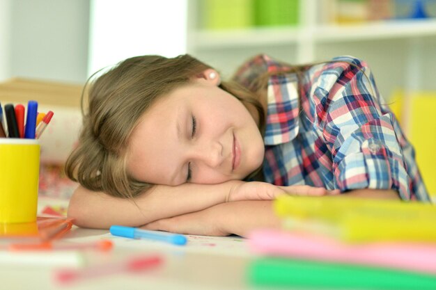 Portrait d'une fille dormant sur des livres