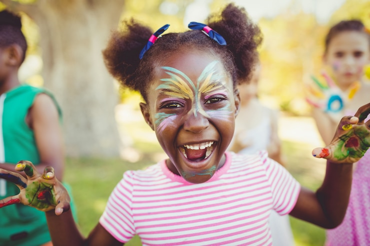 Portrait d'une fille avec du maquillage montrant ses mains peintes