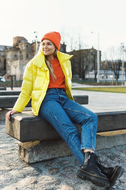 Portrait d'une fille élégante portant un ballon jaune et un bonnet tricoté orange