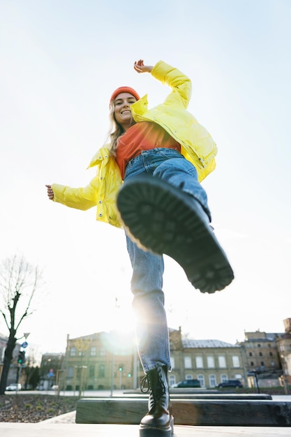 Portrait d'une fille élégante portant un ballon jaune et un bonnet tricoté orange