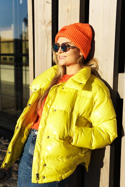 Portrait d'une fille élégante portant un ballon jaune et un bonnet tricoté orange