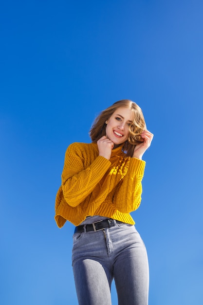 Portrait d&#39;une fille émotive dans un pull jaune et les cheveux courts.