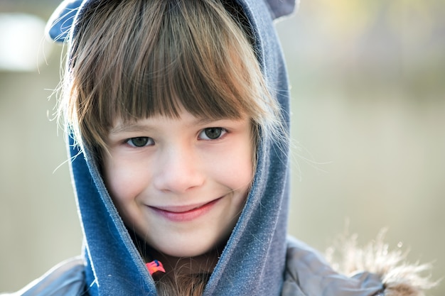 Portrait de fille enfant heureux dans des vêtements chauds en automne à l'extérieur.