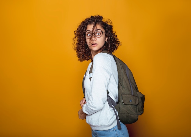 Portrait d'une fille étudiante indienne surprise dans des verres avec un sac à dos.