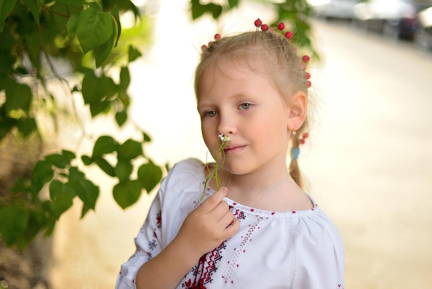 Portrait d'une fille avec une fleur dans une chemise brodée ukrainienne
