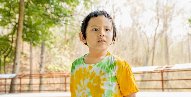 Le portrait de la fille heureuse d'enfant d'Asie dans le fond extérieur naturel.