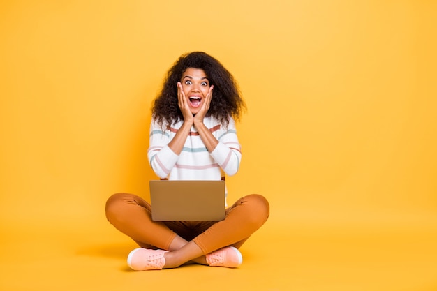 Portrait de fille heureuse ravie assis en posture de lotus navigation ordinateur portable web