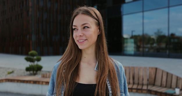 Portrait d'une fille heureuse à la recherche d'appareil photo Gros plan sur le visage d'une belle femme souriante aux cheveux longs