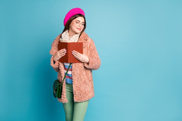 Portrait de fille intelligente rêveuse embrassant le livre