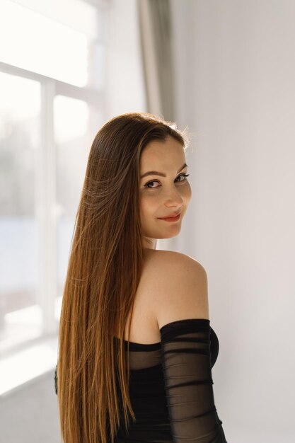 Photo portrait d'une fille mignonne et joyeuse souriante regardant la caméra sur un fond blanc