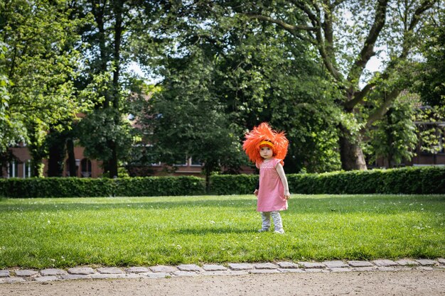 Portrait d'une fille avec une perruque à drapeau belge dans le parc